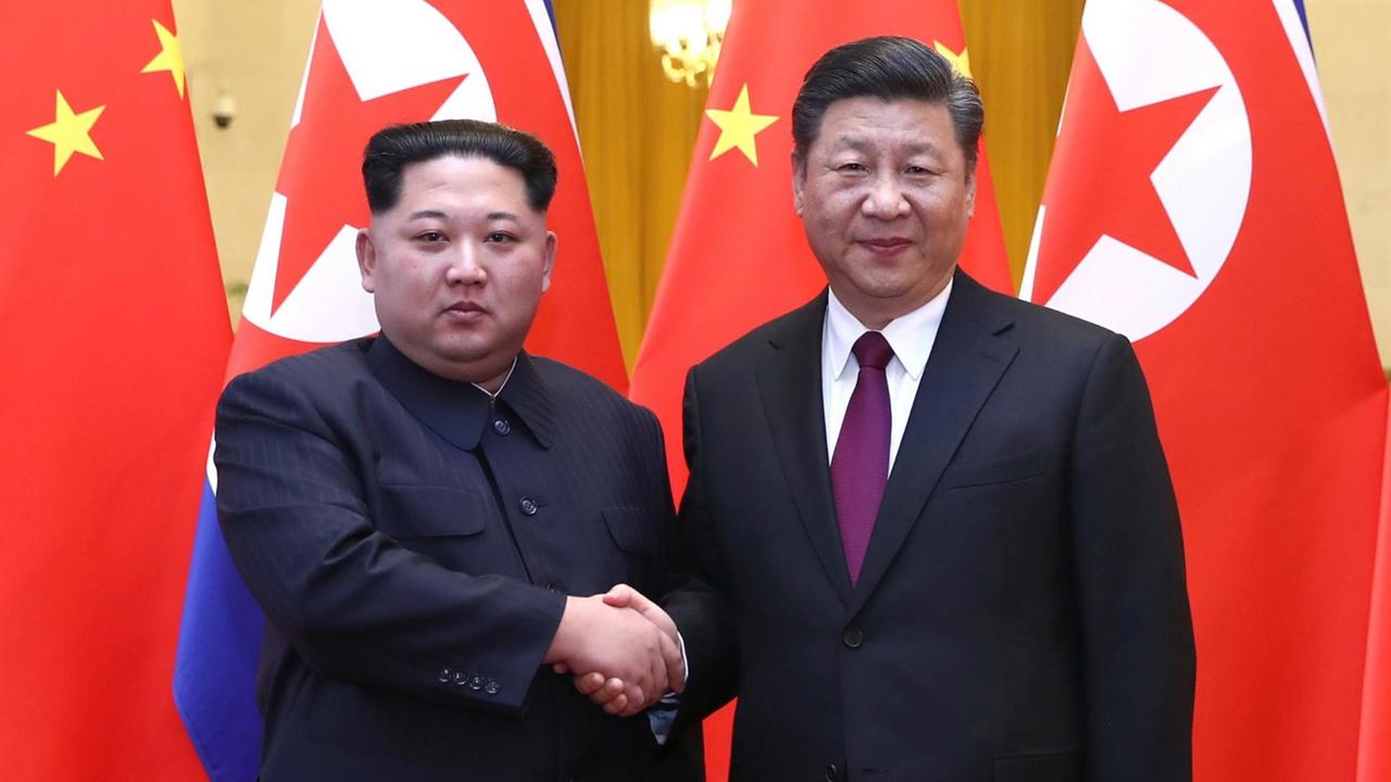 Nordkoreas Machthaber Kim Jong Un (l) und Chinas Präsident Xi Jinping sich die Hand gebend Nordkoreas Machthaber Kim Jong Un (l) und Chinas Präsident Xi Jinping sich die Hand gebend