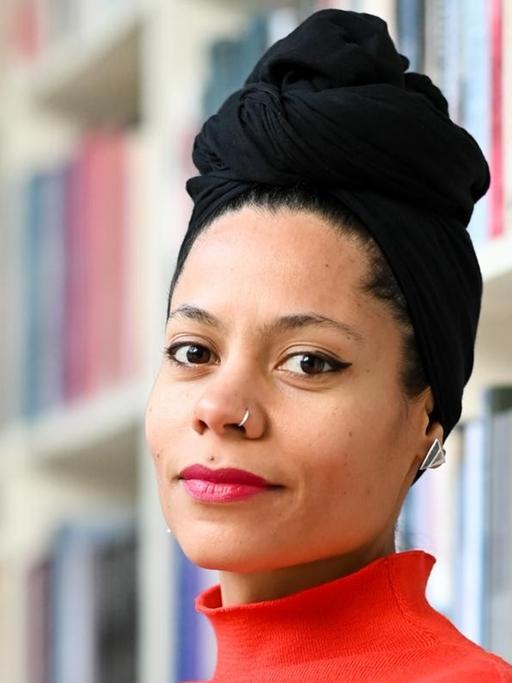 Porträt der Autorin Emilia Roig vor einer Bücherwand. Ihr Buch "Why we matter - Ende der Unterdrückung" über Alltagsrassismus und Zusammenleben ist 2021 erschienen. Sie ist Gründerin und Direktorin des Center for Intersectional Justice (CIJ) in Berlin.