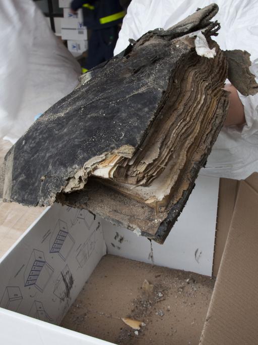 Zwei Monate nach dem Einsturz des historischen Archivs der Stadt Köln bergen und versorgen Helfer und Archivare in den Trümmern gefundene Bücher.