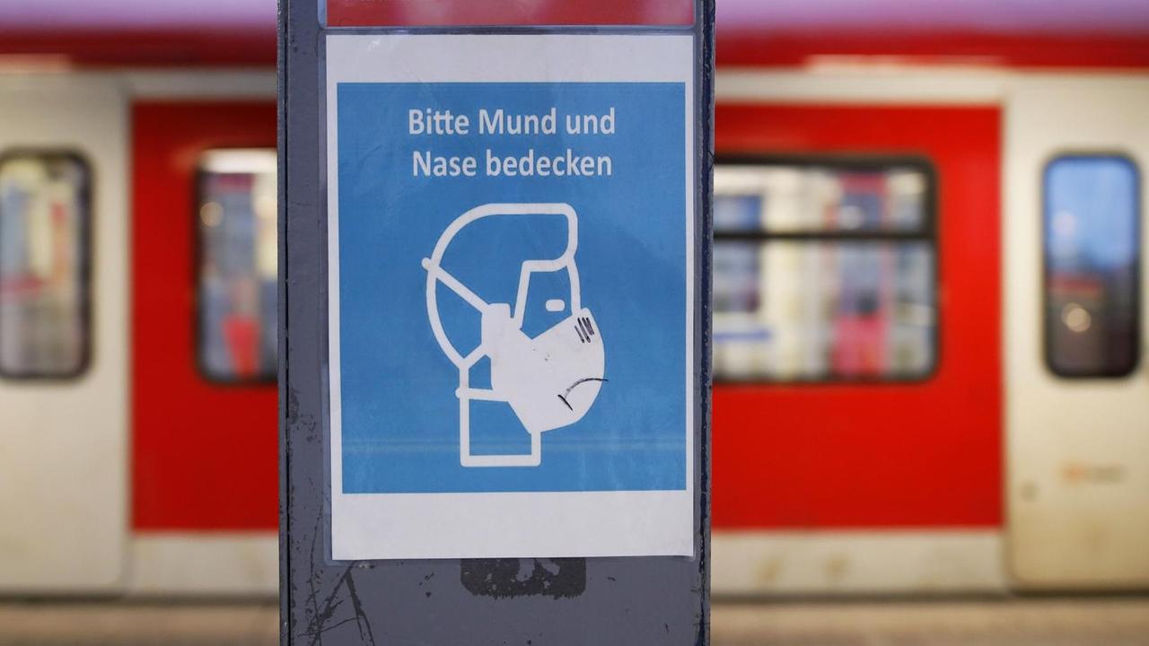 Am Kölner Haupt-Bahnhof gibt es ein Hinweis-Schild für eine Schutz-Maske. Am Kölner Haupt-Bahnhof gibt es ein Hinweis-Schild für eine Schutz-Maske.