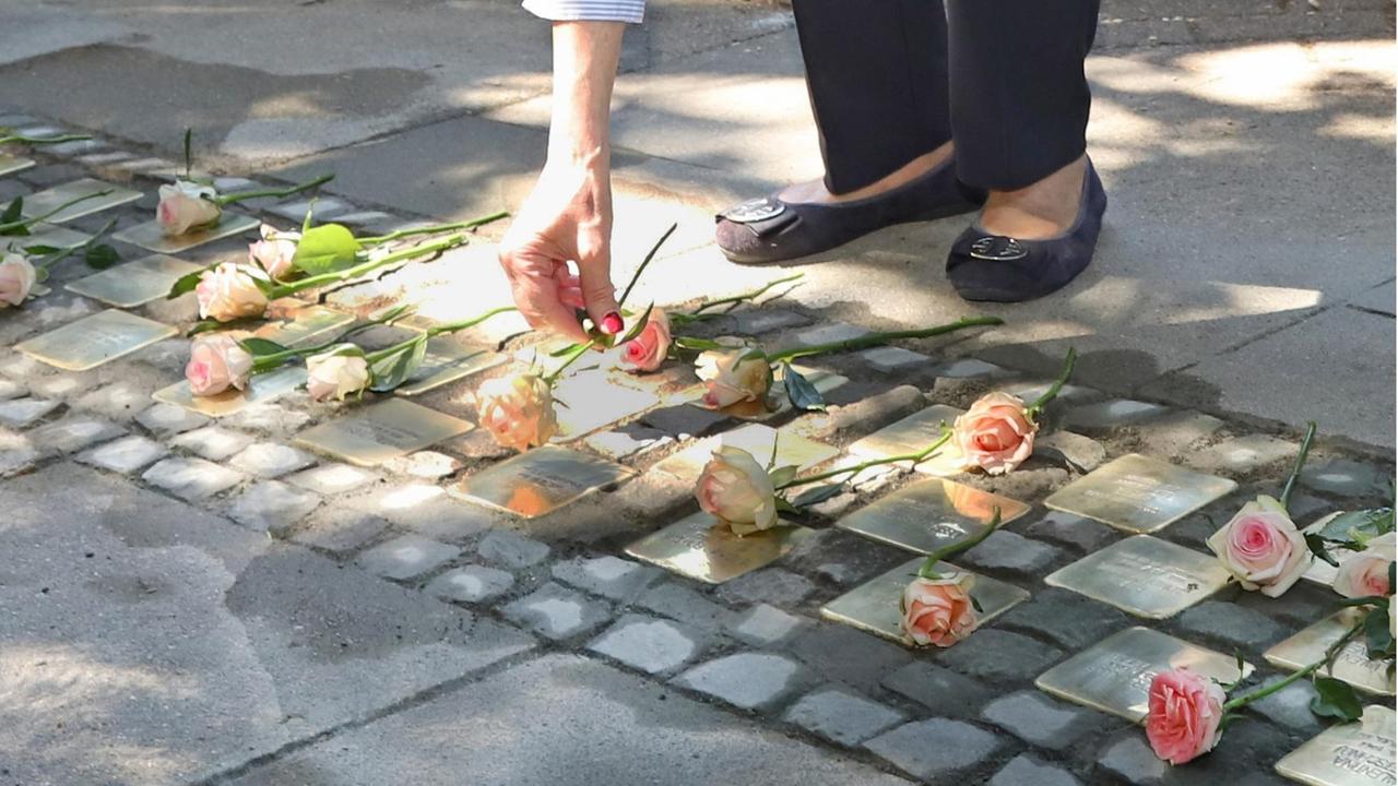 Eine Frau legt eine Rose nieder bei der Einweihung der "Stolpersteine" für die toten Kinder von Zwangarbeiterinnen in Hamburg 