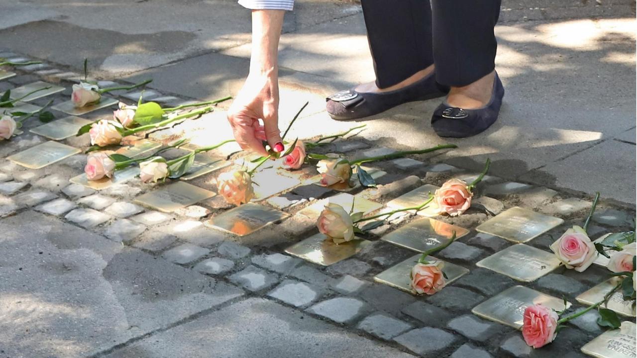 Eine Frau legt eine Rose nieder bei der Einweihung der "Stolpersteine" für die toten Kinder von Zwangarbeiterinnen in Hamburg Eine Frau legt eine Rose nieder bei der Einweihung der "Stolpersteine" für die toten Kinder von Zwangarbeiterinnen in Hamburg