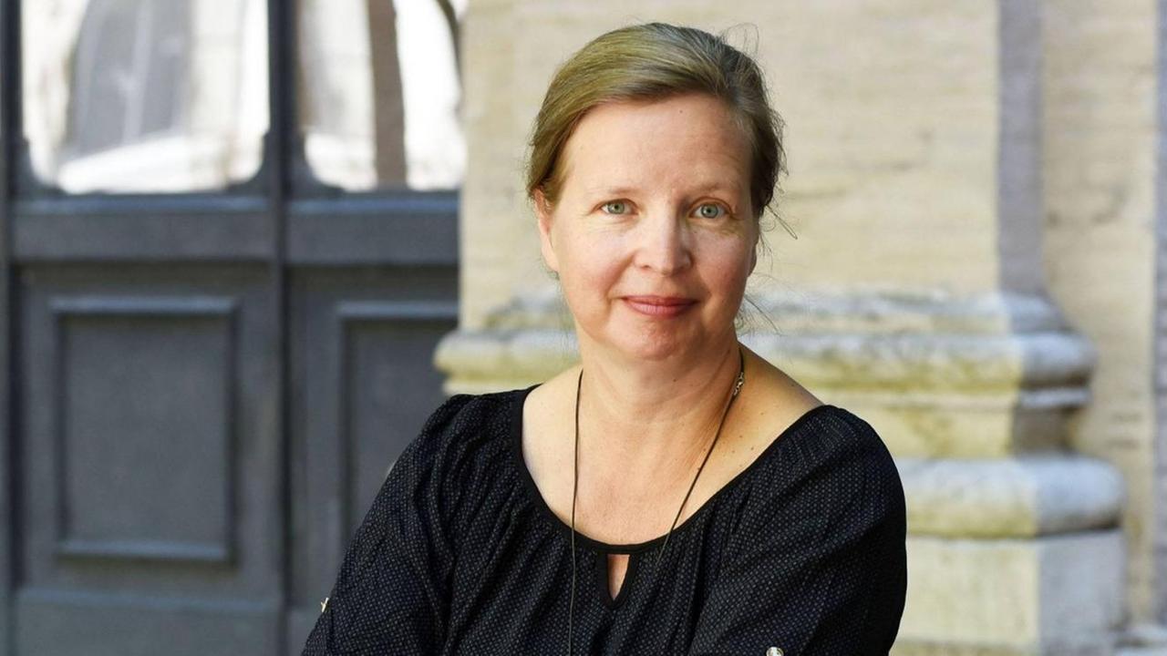 Jenny Erpenbeck in einem sommerlichen, schwarzen Oberteil, die Haar nach hinten gebunden. Jenny Erpenbeck in einem sommerlichen, schwarzen Oberteil, die Haar nach hinten gebunden.