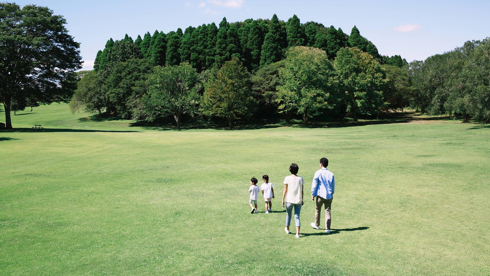 Glückliche japanische Familie in einem Park