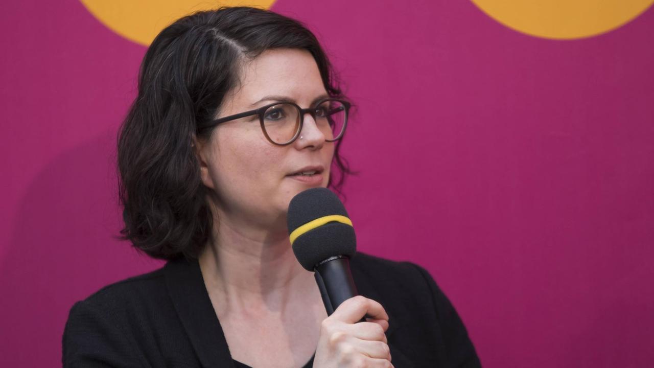 Zu sehen ist die Schriftstellerin Isabelle Lehn, die ein Mikro in der Hand hält. Zu sehen ist die Schriftstellerin Isabelle Lehn, die ein Mikro in der Hand hält.