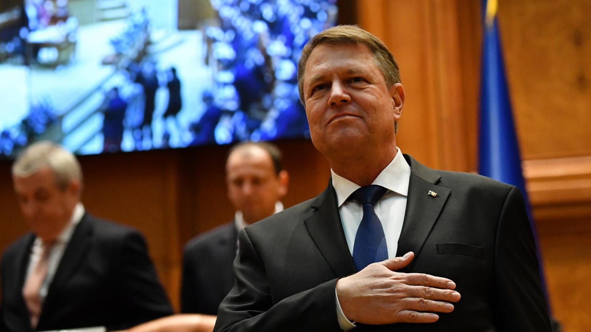 Klaus Iohannis im rumänischen Parlament, die rechte Hand auf die linke Brust gelegt Klaus Iohannis im rumänischen Parlament, die rechte Hand auf die linke Brust gelegt