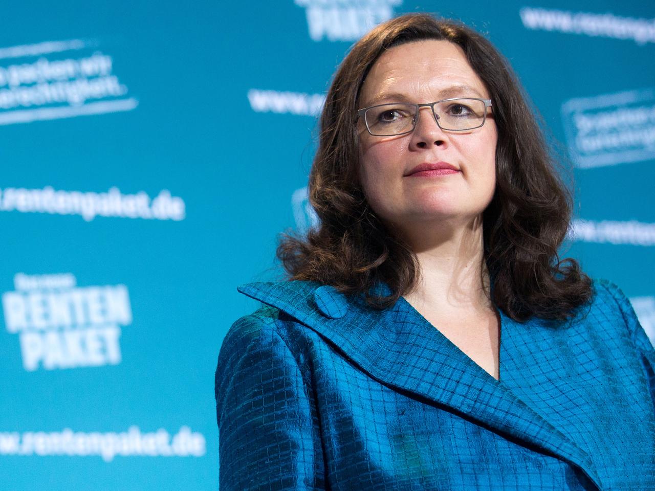 Arbeitsministerin Andrea Nahles steht vor einem blauen Hintergrund mit der Aufschrift "Rentenpaket".