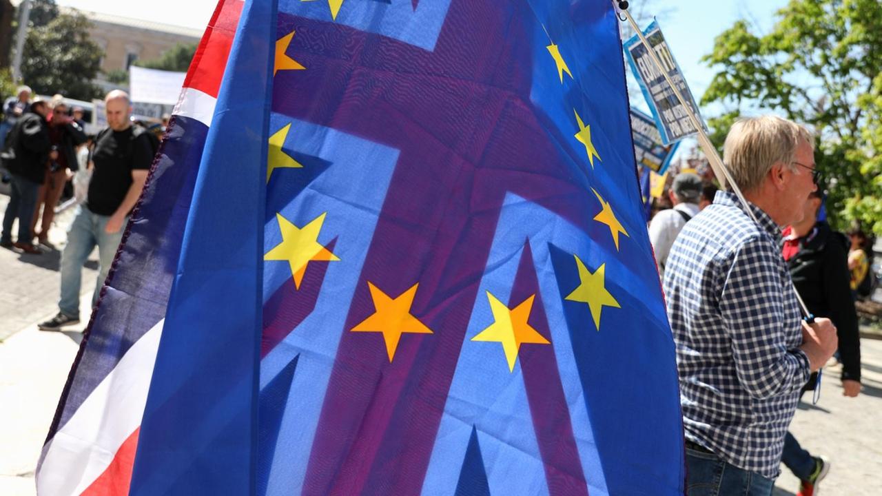 Ein Demonstrant mit einer EU- und einer britischen Flagge über der Schulter. Ein Demonstrant mit einer EU- und einer britischen Flagge über der Schulter.