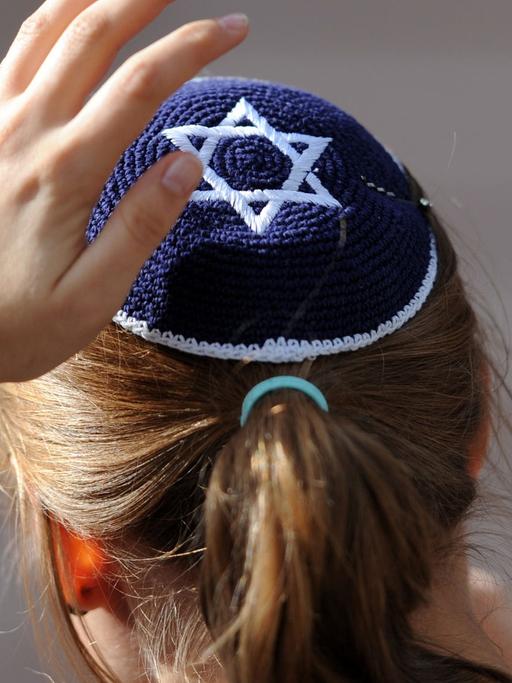 Eine junge Frau mit Kippa, ihr Hinterkopf ist zu sehen