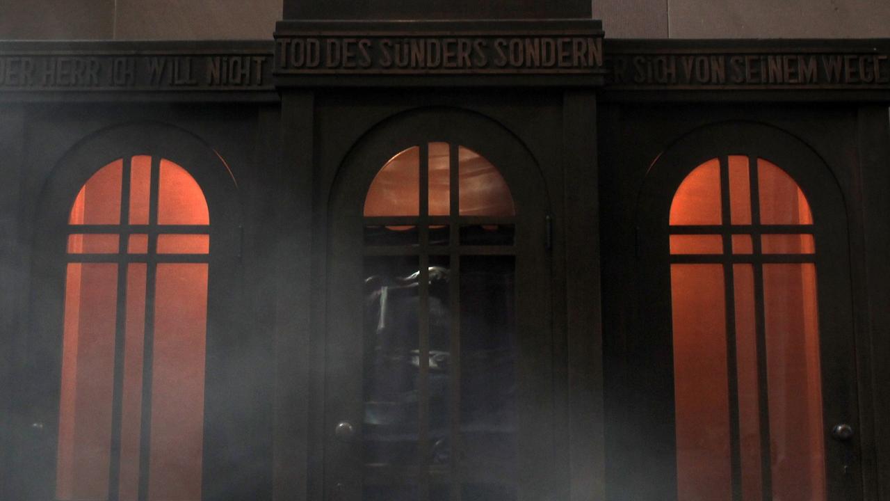 In einem leeren Beichstuhl brennen in der Laurentiuskapelle im Dom in Mainz die Lichter.