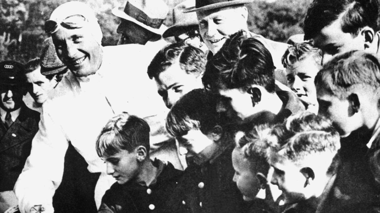 Der deutsche Rennfahrer Hans Stuck (l), umringt von jugendlichen Fans, aufgenommen im Jahr 1934. Der deutsche Rennfahrer Hans Stuck (l), umringt von jugendlichen Fans, aufgenommen im Jahr 1934.