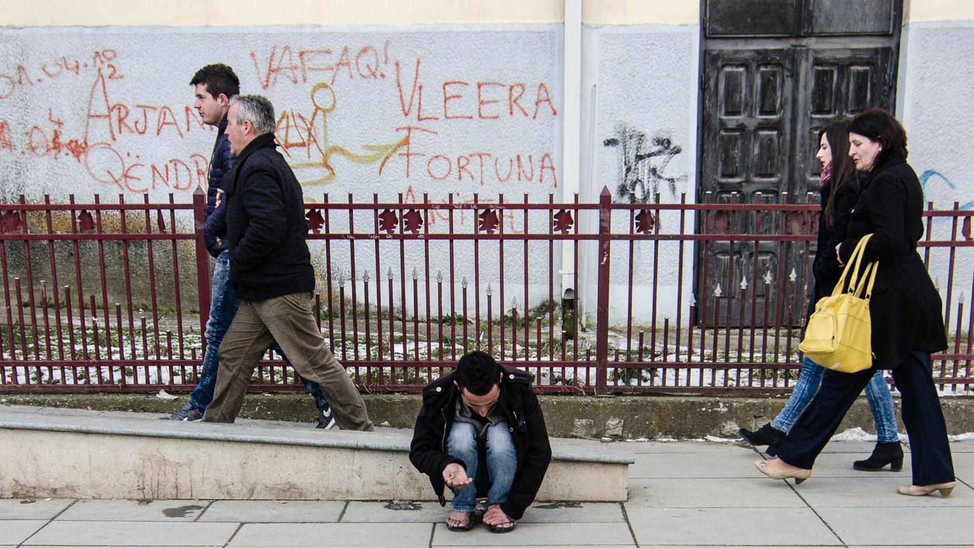 Ein Mann bettelt barfuß um Geld in in Pristina, der Hauptstadt des Kosovo. Ein Mann bettelt barfuß um Geld in in Pristina, der Hauptstadt des Kosovo.