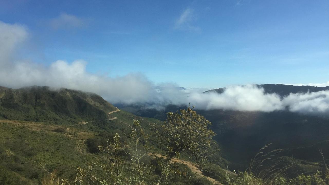 Grüne Hügel in Bolivien, über die Wolken gleiten.