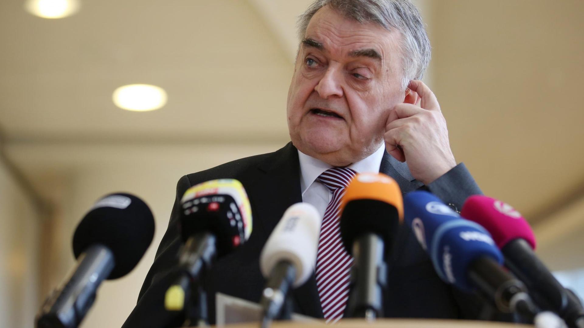 Nordrhein-Westfalens Innenminister Herbert Reul (CDUsteht in einem dunklen Anzug hinter einem Rednerpult mit Mikrofonen. Nordrhein-Westfalens Innenminister Herbert Reul (CDUsteht in einem dunklen Anzug hinter einem Rednerpult mit Mikrofonen.