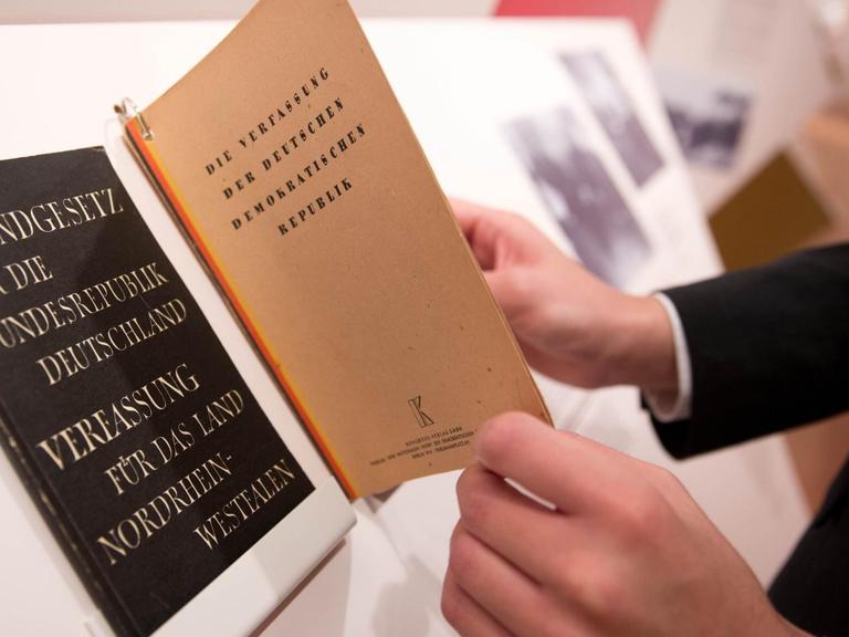 Ein Besucher blättert am 28.10.2015 im Martin-Gropius-Bau in Berlin in der Ausstellung «Russland und Deutschland. Von der Konfrontation zur Zusammenarbeit» neben dem Grundgesetz der Bundesrepublik Deutschland in einer Verfassung der DDR.
