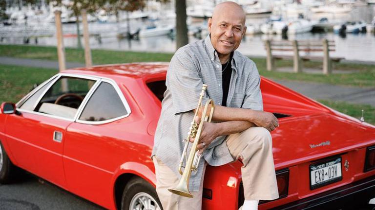 Der Jazz-Trompeter Eddie Henderson lehnt amn einem roten Sportwagen. Der Jazz-Trompeter Eddie Henderson lehnt amn einem roten Sportwagen.