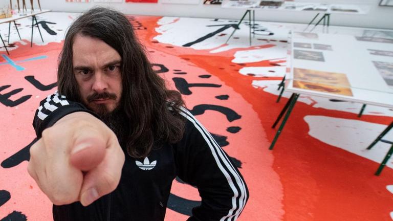 Jonathan Meese, Maler und Aktionskünstler, steht bei einem Interviewtermin in dem noch geschlossenen Ausstellungsraum der Ausstellung "Die Irrfahrten des Meese". Die Ausstellung in der Neuen Pinakothek, welche Werke aus 25 Jahren zeigt. Jonathan Meese, Maler und Aktionskünstler, steht bei einem Interviewtermin in dem noch geschlossenen Ausstellungsraum der Ausstellung "Die Irrfahrten des Meese". Die Ausstellung in der Neuen Pinakothek, welche Werke aus 25 Jahren zeigt.