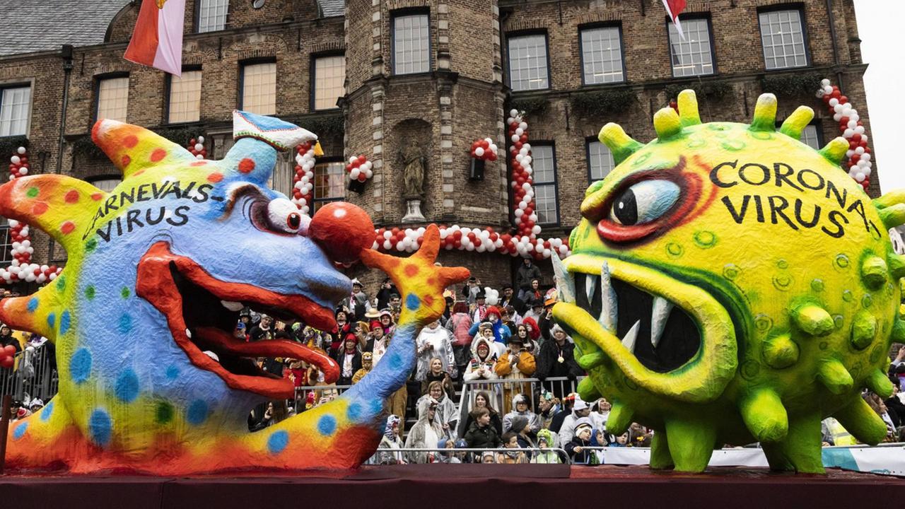 Beim Rosenmontagszug in Düsseldorf zeigt am 24. Februar 2020 ein Bazzillus carneval aus Pappmachée dem Coronavirus eine lange Nase. Beim Rosenmontagszug in Düsseldorf zeigt am 24. Februar 2020 ein Bazzillus carneval aus Pappmachée dem Coronavirus eine lange Nase.