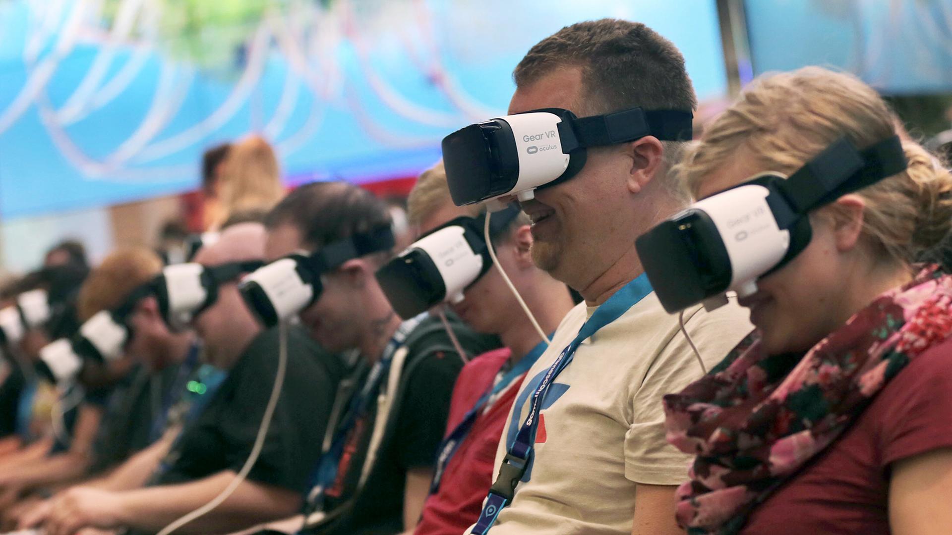 Besucher der Gamescom 2016 in Köln tragen VR-Brillen. 17.8.2016