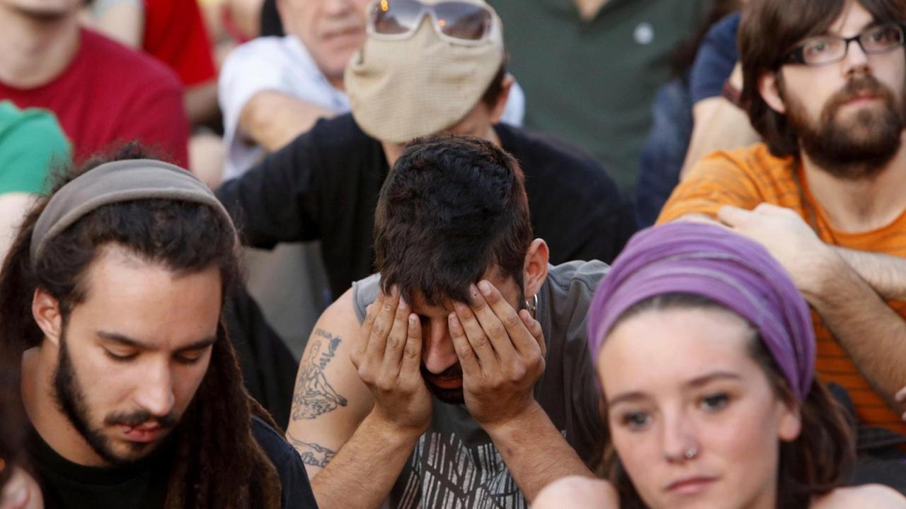 Junge Demonstranten sitzen auf einem Platz in Madrid, Spanien. Sie protestieren gegen die Spar- Arbeitsmarkt- und Bildungspolitik der spanischen Regierung. Junge Demonstranten sitzen auf einem Platz in Madrid, Spanien. Sie protestieren gegen die Spar- Arbeitsmarkt- und Bildungspolitik der spanischen Regierung.