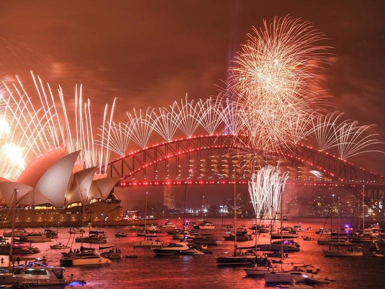 Nächtlicher Blick auf den Hafen und die Oper von Sydney mit großem Feuerwerk.