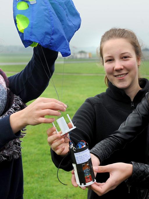 Lilli Freischen, Maria Höller und Hannah Besser vom Satelliten-Projekt "URSinvestigators" der Erzbischhöflichen Ursulinenschule in Köln führen am 7.10.2015 auf dem Flugplatz in Rotenburg ihre Satelliten-Konstruktion vor, mit der sie an dem Cansat-Wettbewerb 2015 teilnehmen.