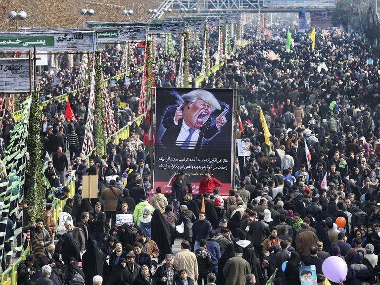 Menschen nehmen in Teheran (Iran) an der jährlichen Kundgebung anlässlich des Jahrestags der islamischen Revolution teil. Einige Teilnehmer halten eine Karikatur des US-Präsidenten Trump hoch.