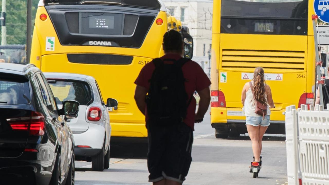 29.07.2019, Berlin: Zwei E-Scooter Fahrer fahren auf dem Fahrradweg an der Karl-Liebknecht Straße hinter einem BVG-Bus 29.07.2019, Berlin: Zwei E-Scooter Fahrer fahren auf dem Fahrradweg an der Karl-Liebknecht Straße hinter einem BVG-Bus