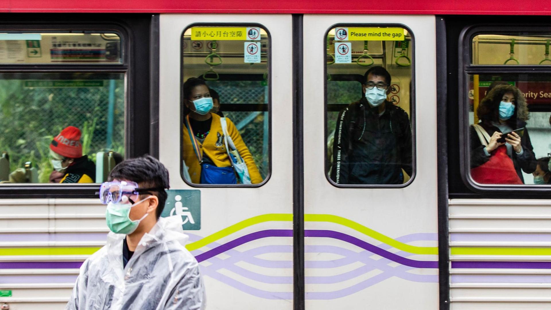 China, Hongkong: Die Fahrgäste einer Straßenbahn tragen Atemschutzmasken. China, Hongkong: Die Fahrgäste einer Straßenbahn tragen Atemschutzmasken.
