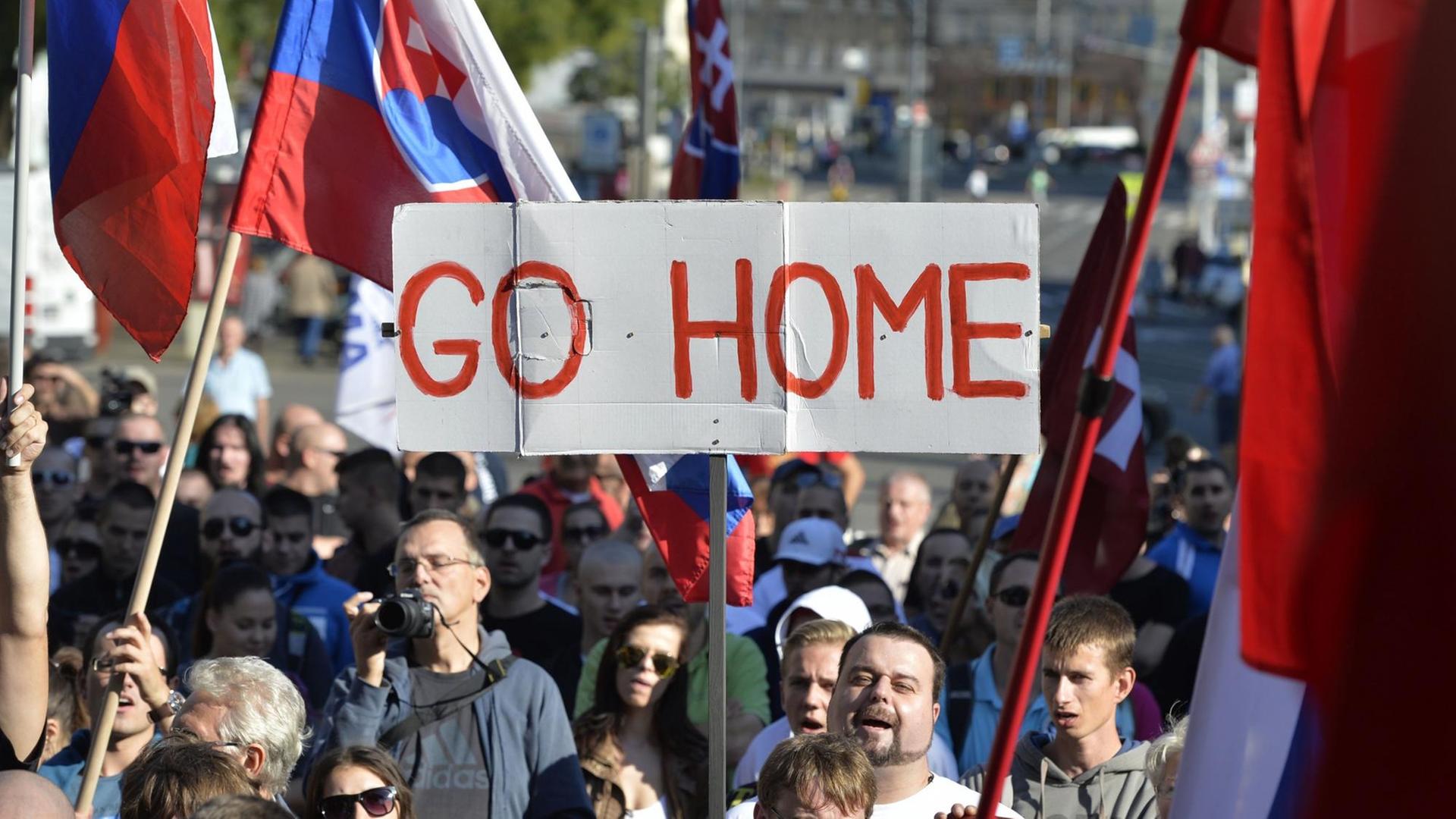 Teilnehmer einer Demonstration gegen Flüchtlinge in der slowakischen Hauptstadt Bratislava halten Flaggen und ein Banner mit der Aufschrift "Go Home" hoch. Teilnehmer einer Demonstration gegen Flüchtlinge in der slowakischen Hauptstadt Bratislava halten Flaggen und ein Banner mit der Aufschrift "Go Home" hoch.