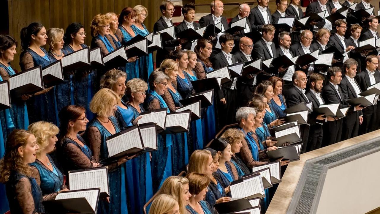 Die Frauen des Rundfunkchores in blauen Kleidern stehen mit ihren Kollegen auf einer Empore im Gewandhaus Leipzig. Die Frauen des Rundfunkchores in blauen Kleidern stehen mit ihren Kollegen auf einer Empore im Gewandhaus Leipzig.