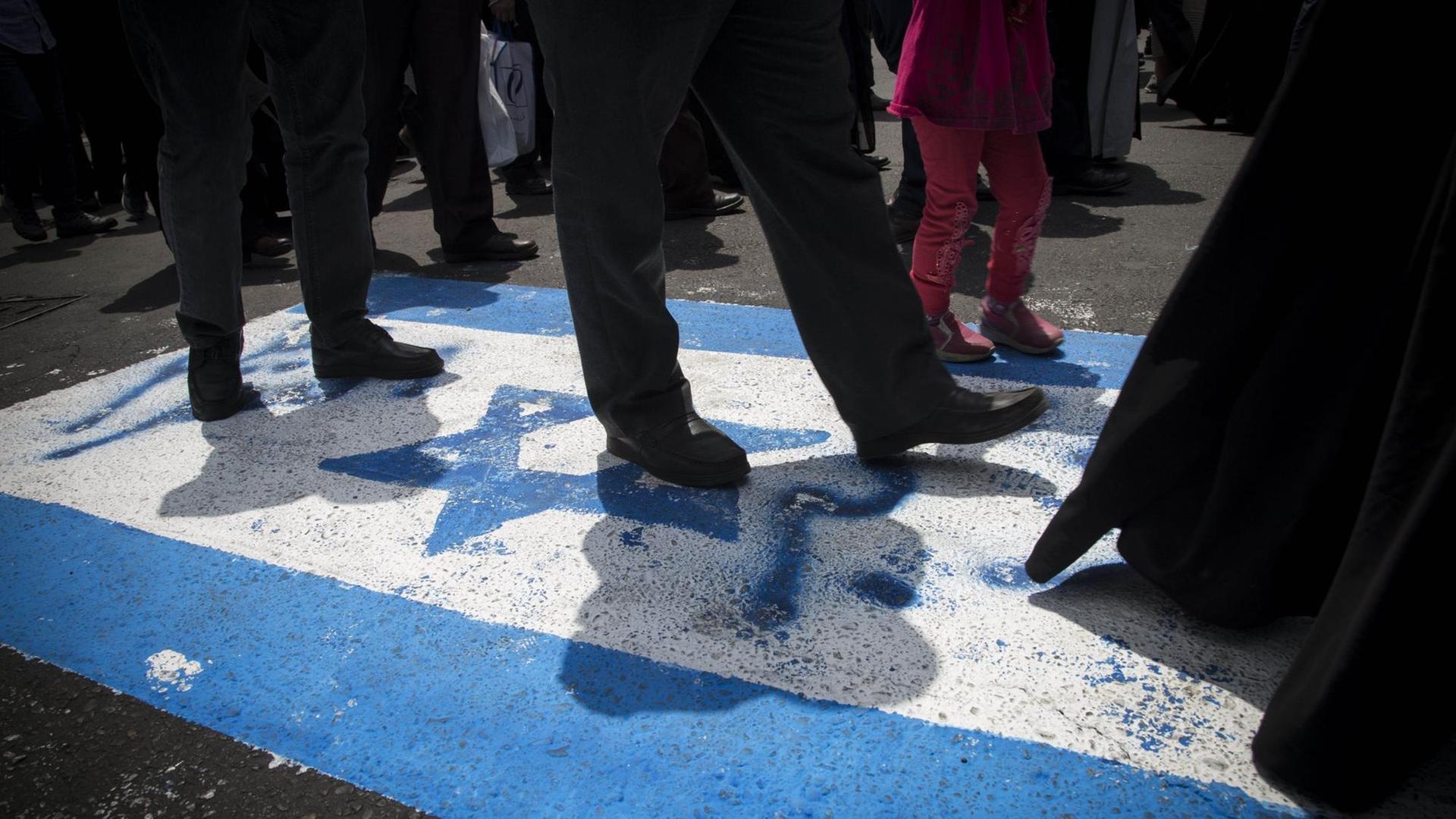 Iraner laufen über die israelische Flagge. Iraner laufen über die israelische Flagge.