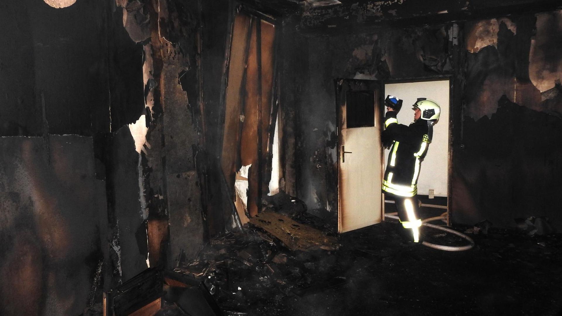 Ein Feuerwehrmann löscht am 08.10.2015 in einer geplanten Flüchtlingsunterkunft in Grimma (Sachsen) einen Brand. Foto: Frank Schmidt/dpa Ein Feuerwehrmann löscht am 08.10.2015 in einer geplanten Flüchtlingsunterkunft in Grimma (Sachsen) einen Brand. Foto: Frank Schmidt/dpa