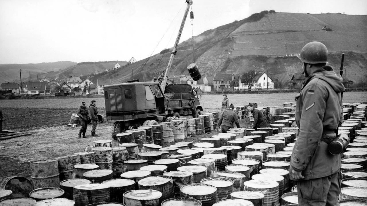 Fässer mit Gasgranaten aus dem Ersten Weltkrieg werden im März 1962 in Monzingen vor ihrer Verladung auf Eisenbahnwaggons von Bundeswehrsoldaten bewacht. 