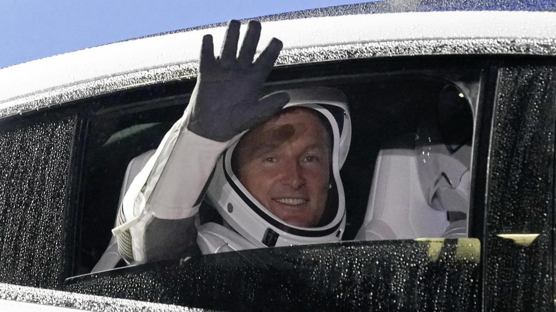Matthias Maurer winkt aus einem Auto-Fenster. Matthias Maurer winkt aus einem Auto-Fenster.
