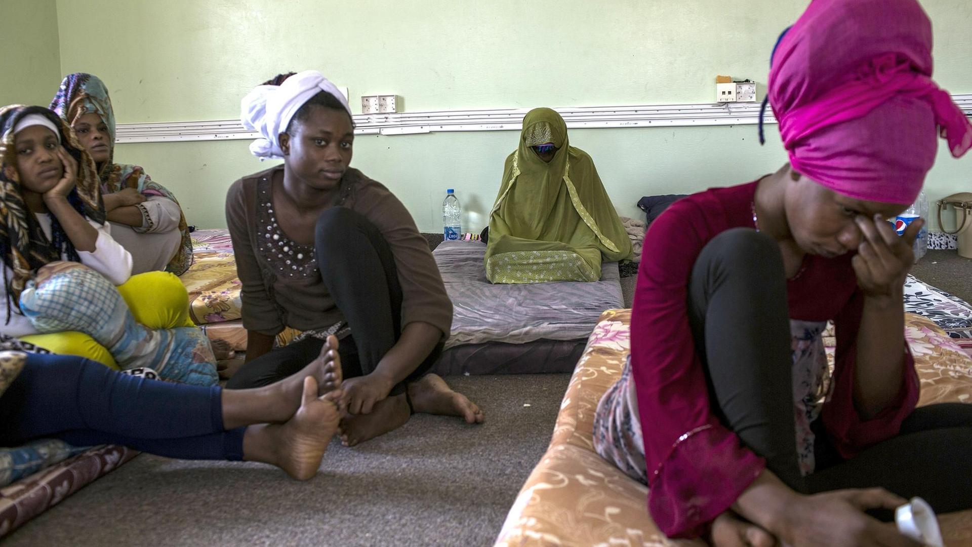 Nigerian women sit at Libya's Karareem detention centre near Misrata, a town half-way between Sirte and Tripoli, on September 25, 2016. Around 230 migrants, among them 15 women, mostly coming from sub-Saharan countries including Nigeria, Senegal, Chad, Mali, Sudan, Eritrea, Somalia and also Egypt and Bangladesh are detained in the centre. Some of the migrants arrived in Libya to look for a job, others to find a way to reach Europe. / AFP PHOTO / Fabio Bucciarelli