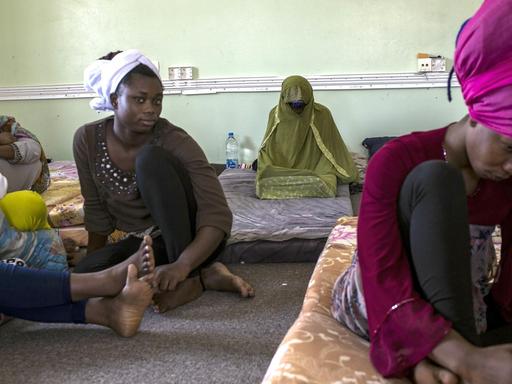 Nigerian women sit at Libya's Karareem detention centre near Misrata, a town half-way between Sirte and Tripoli, on September 25, 2016. Around 230 migrants, among them 15 women, mostly coming from sub-Saharan countries including Nigeria, Senegal, Chad, Mali, Sudan, Eritrea, Somalia and also Egypt and Bangladesh are detained in the centre. Some of the migrants arrived in Libya to look for a job, others to find a way to reach Europe. / AFP PHOTO / Fabio Bucciarelli