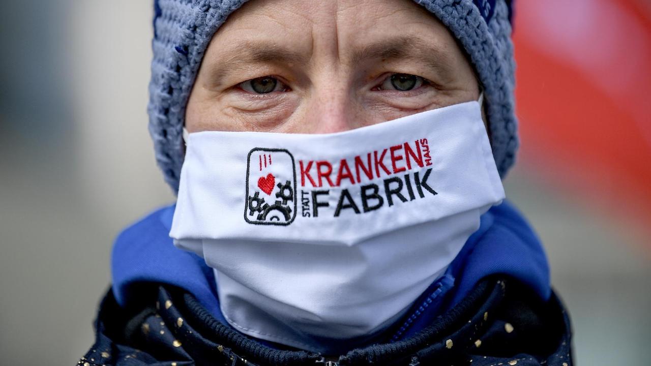 Eine Demonstrantin trägt einen Mundschutz mit der Aufschrift «Krankenhaus statt Krankenfabrik» vor dem Kanzleramt bei der Protestkundgebung von der Partei «Die Linke» im Rahmen der Kampagne «Menschen vor Profite: Pflegenotstand stoppen!». Eine Demonstrantin trägt einen Mundschutz mit der Aufschrift «Krankenhaus statt Krankenfabrik» vor dem Kanzleramt bei der Protestkundgebung von der Partei «Die Linke» im Rahmen der Kampagne «Menschen vor Profite: Pflegenotstand stoppen!».