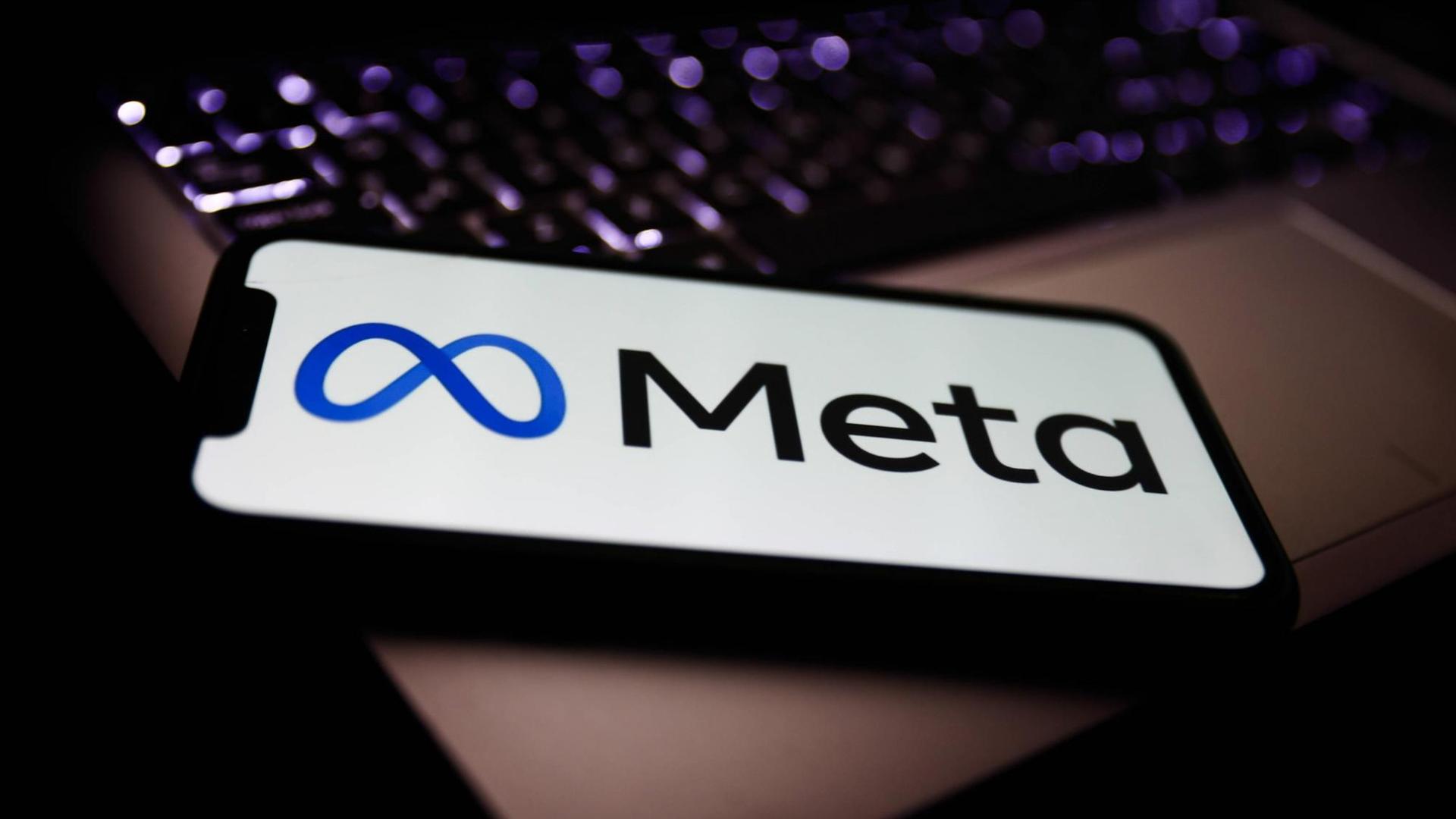 Das neue Logo von Meta (ehemals Facebook) auf einem Smartphone, das auf einem Laptop liegt. Das neue Logo von Meta (ehemals Facebook) auf einem Smartphone, das auf einem Laptop liegt.