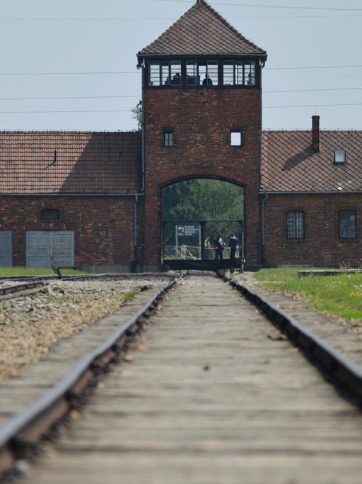 Schienen laufen auf einen Turm des ehemaligen NS-Konzentrationslagers Auschwitz-Birkenau zu.