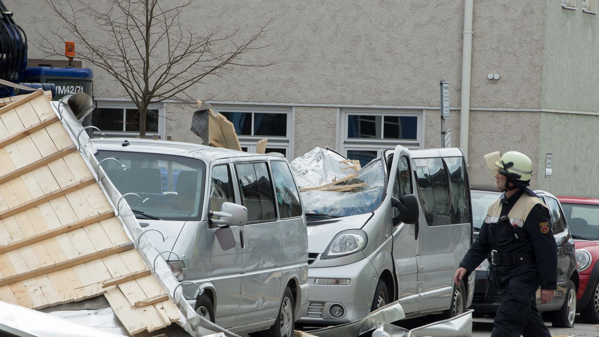 Ein Feuerwehrmann läuft am 31.03.2015 in Weilheim (Bayern) an einem stark beschädigtem Auto vorbei Ein Feuerwehrmann läuft am 31.03.2015 in Weilheim (Bayern) an einem stark beschädigtem Auto vorbei