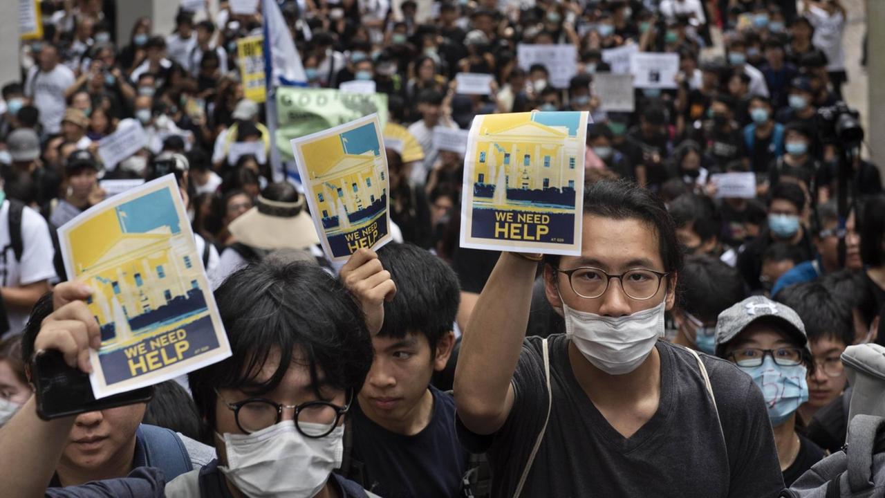 Protestanten in Hongkong halten Schilder hoch, um die Staaten der G20 um Hilfe zu bitten.