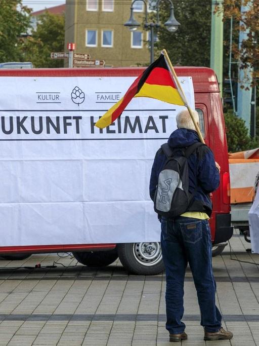 Teilnehmer einer Demonstration des mit der AfD verbundene Vereins "Zukunft Heimat" mit einer Deutschlandflagge