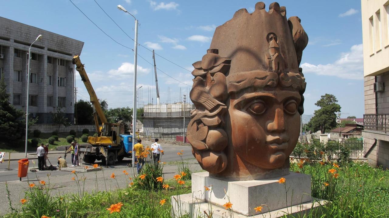 Ein Skulptur, die einen Frauenkopf darstellt, steht am "Platz der armenischen Wiedergeburt" im Zentrum von Stepanakert in der Region Bergkarabach, dahinter sind Bauarbeiten im Gange. Ein Skulptur, die einen Frauenkopf darstellt, steht am "Platz der armenischen Wiedergeburt" im Zentrum von Stepanakert in der Region Bergkarabach, dahinter sind Bauarbeiten im Gange.