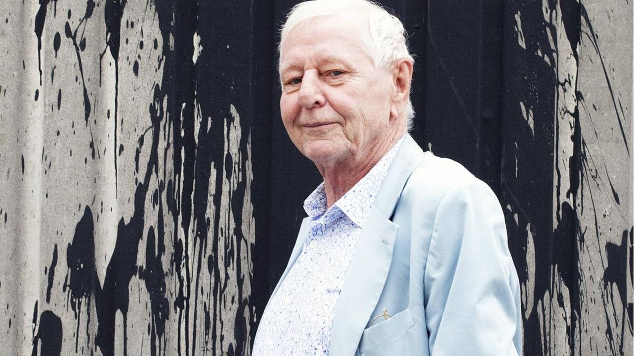 Hans Magnus Enzensberger steht vor einer mit Farbe bespritzten Wand Hans Magnus Enzensberger steht vor einer mit Farbe bespritzten Wand