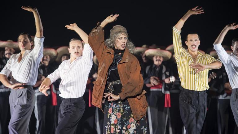 Tanzszene aus "Candide" von Leonard Berstein in der Inszenierung von Barrie Kosky mit Anne Sofie von Otter als Die alte Dame vorne in der Mitte zwischen den Tänzern des Ensembles.
