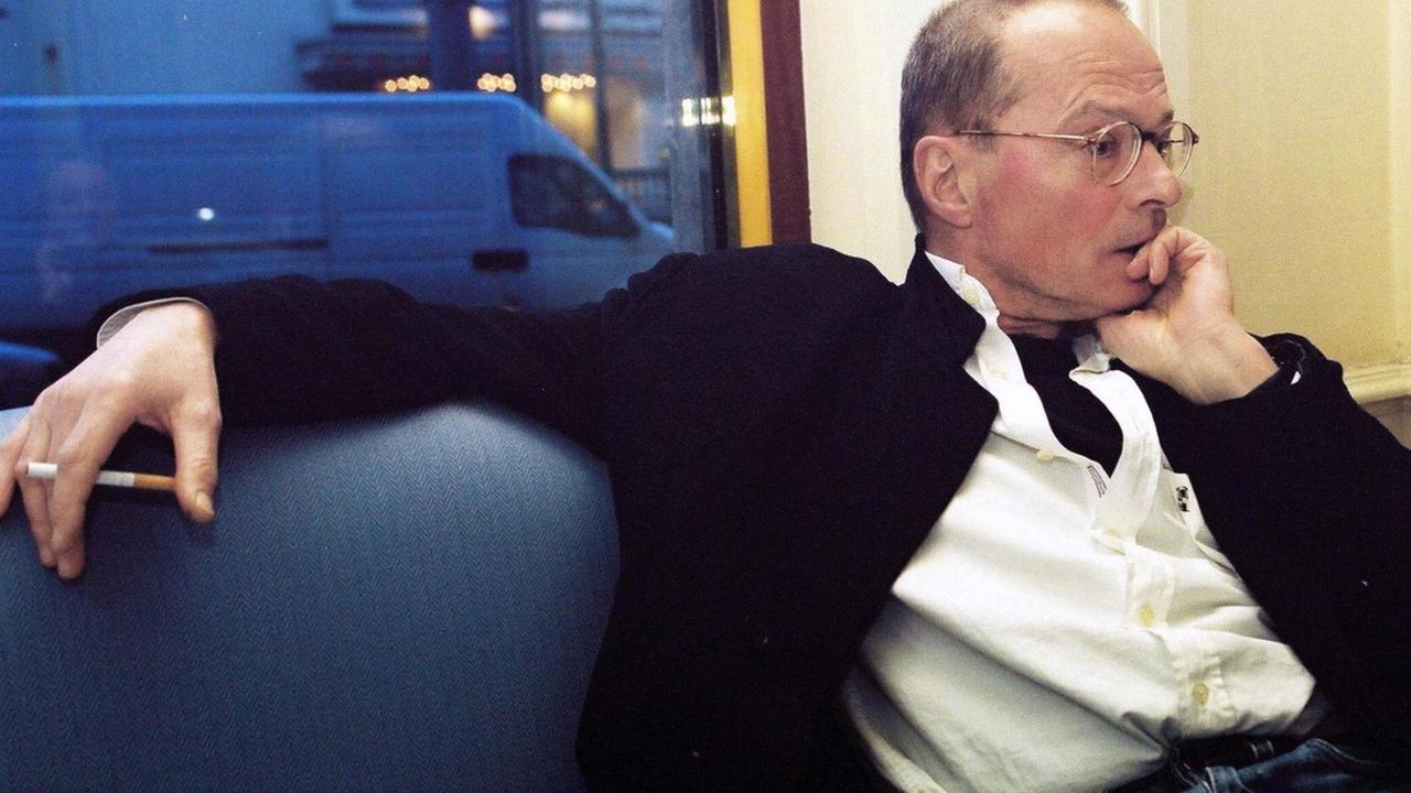 Wolf Wondratschek sitzt nachdenklich auf einer Couch und hält in lockerer Pose eine Zigarette, aufgenommen 2015 Wolf Wondratschek sitzt nachdenklich auf einer Couch und hält in lockerer Pose eine Zigarette, aufgenommen 2015