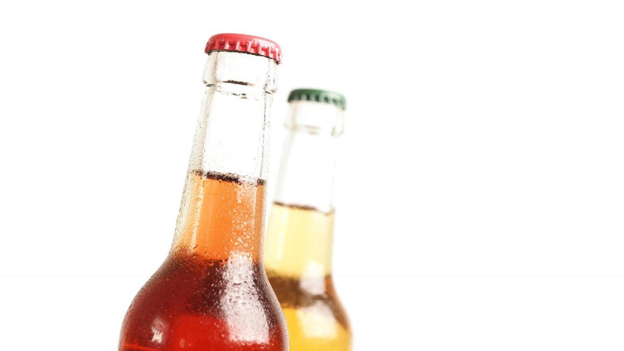 Zwei Flaschen eisgekühlte Biolimonade vor weißem Hintergrund. Zwei Flaschen eisgekühlte Biolimonade vor weißem Hintergrund.