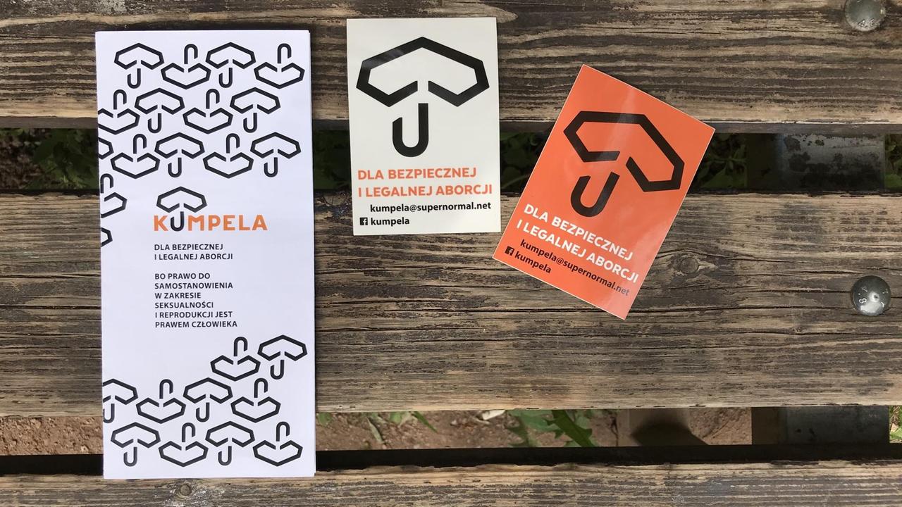 Mehrere Broschüren von Kumpela liegen auf einer Holzbank. Mehrere Broschüren von Kumpela liegen auf einer Holzbank.