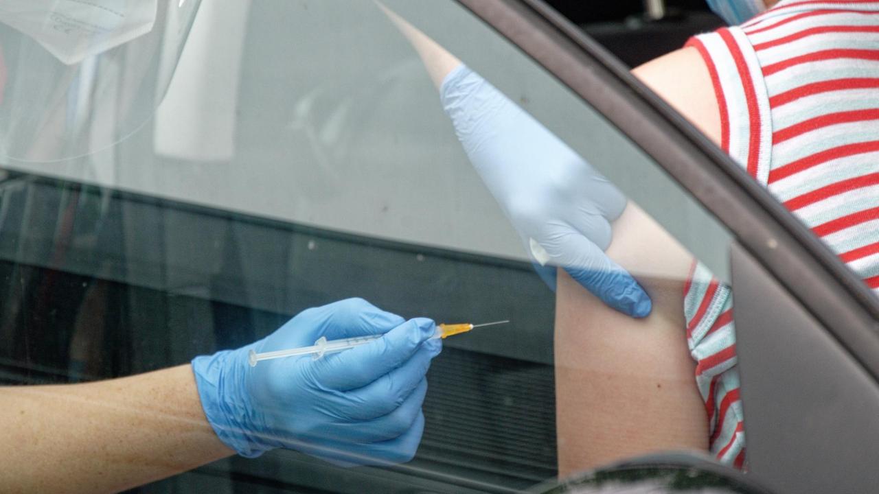 Ein Mitarbeiter spritzt bei einer Drive-in-Impfaktion eine Dosis Impfstoff von Johnson & Johnson in den Arm einer Frau, die in einem Auto sitzt. Ein Mitarbeiter spritzt bei einer Drive-in-Impfaktion eine Dosis Impfstoff von Johnson & Johnson in den Arm einer Frau, die in einem Auto sitzt.